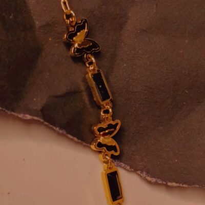 Gold bracelet with black butterfly charms and rectangular stones