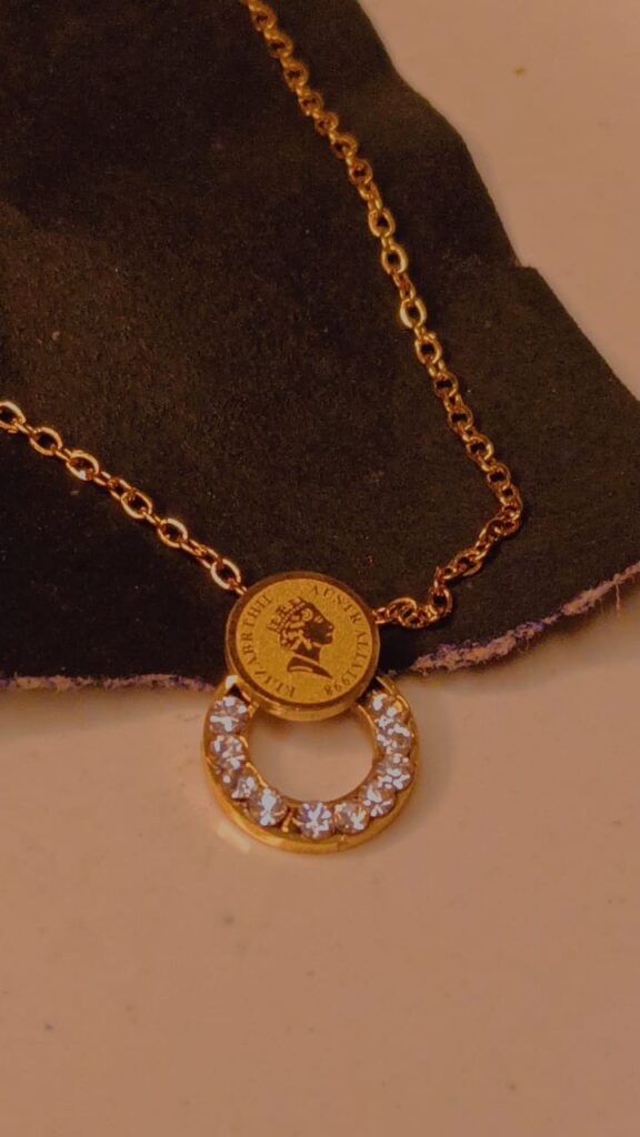 Golden coin and crystal half-moon pendent necklace on gold chain
