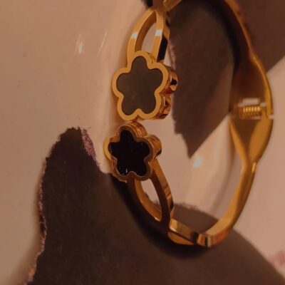 Gold barcelet with twin black clover charms and polished finish