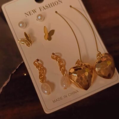Gold combo earrings set with butterfly, pearl, and heart designs on display card.
