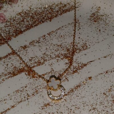 Golden clover and crystal circle pendent necklace on a gold chain