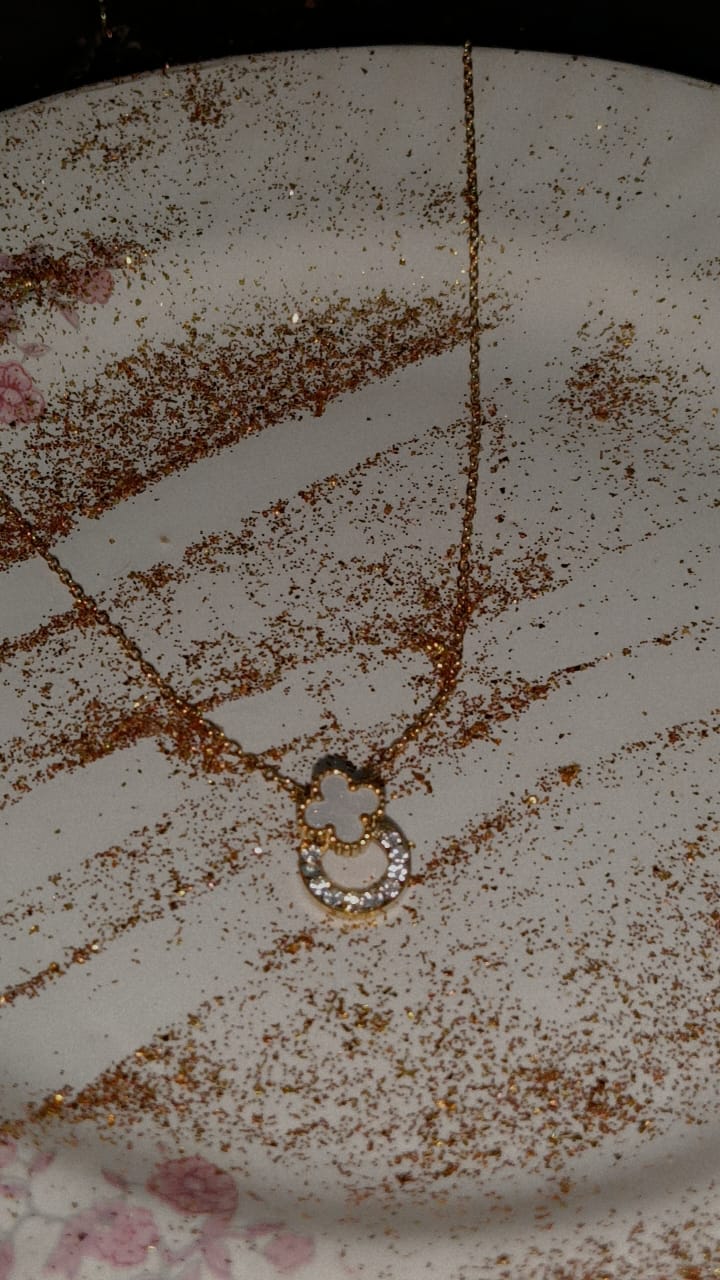 Golden clover and crystal circle pendent necklace on a gold chain